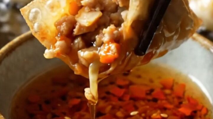 Golden crispy rice paper dumplings piled on a plate with chili crisp and soy sauce