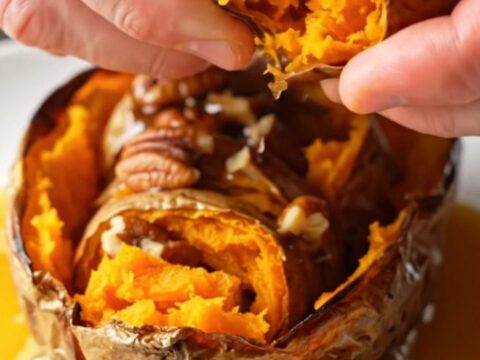 Crispy accordion sweet potatoes on a platter, drizzled with maple pecan butter
