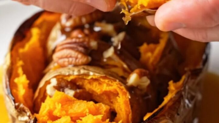 Crispy accordion sweet potatoes on a platter, drizzled with maple pecan butter