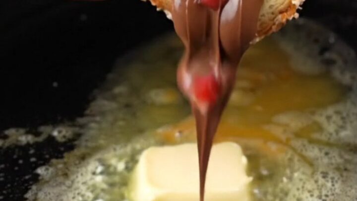 Golden French toast roll-ups coated in cinnamon sugar, with melted Nutella and strawberries oozing out