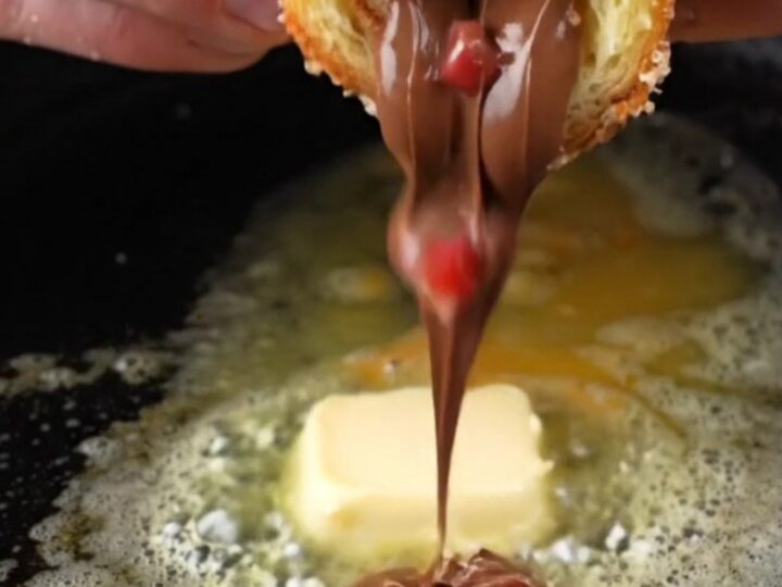 Golden French toast roll-ups coated in cinnamon sugar, with melted Nutella and strawberries oozing out