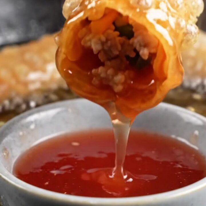 Crispy rice paper egg rolls with blistered golden exterior on a plate with sweet plum dipping sauce