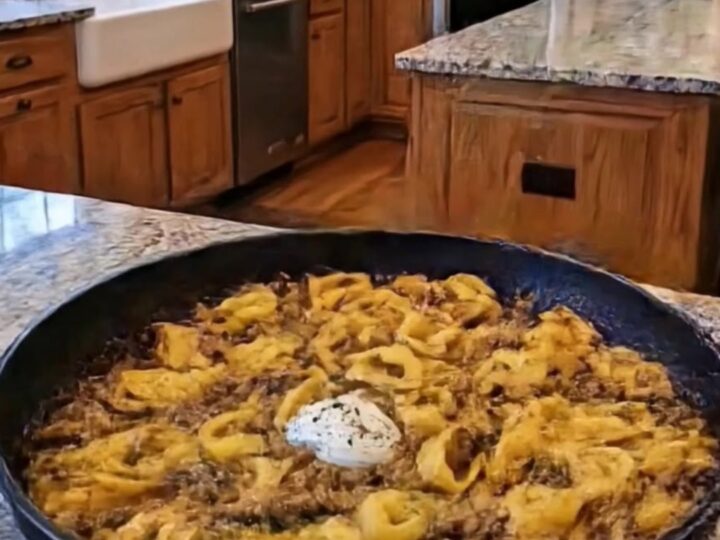 A close-up of creamy beef tortellini in a black pan with steam rising.