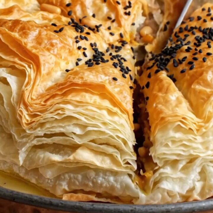 Golden crispy Turkish tray börek with spiced beef filling, sliced into squares
