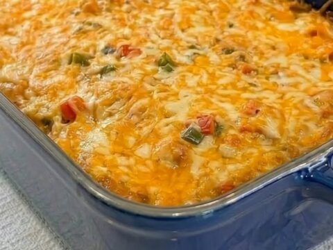 A spatula scooping into a cheesy King Ranch chicken casserole, stretching thick melted golden cheese.
