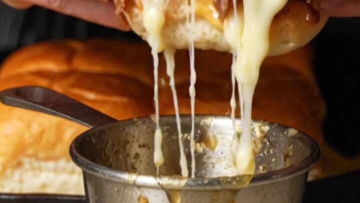 Golden French dip sliders with melted provolone and caramelized onions, served with a cup of au jus for dipping.