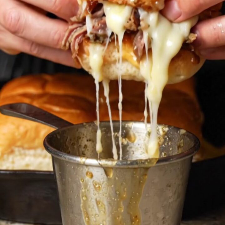 Golden French dip sliders with melted provolone and caramelized onions, served with a cup of au jus for dipping.