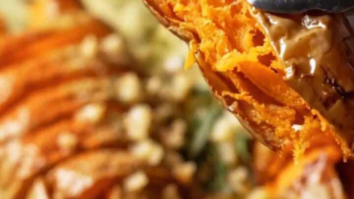 Crispy accordion sweet potatoes on a platter, drizzled with garlic herb butter