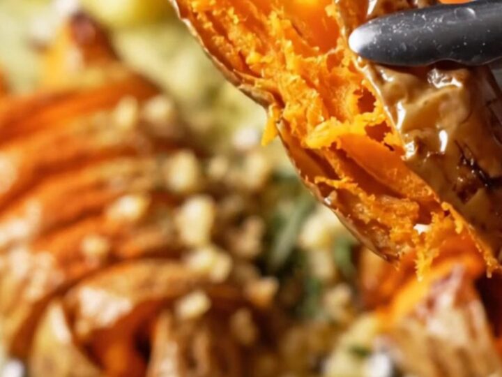 Crispy accordion sweet potatoes on a platter, drizzled with garlic herb butter