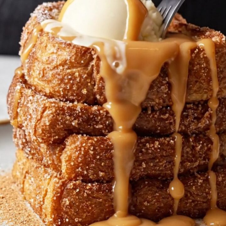 Giant stack of churro French toast topped with vanilla ice cream and dulce de leche