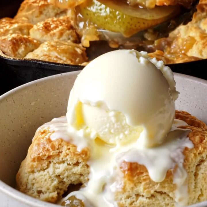Skillet cinnamon pear cobbler with golden buttermilk biscuit topping and melting vanilla ice cream