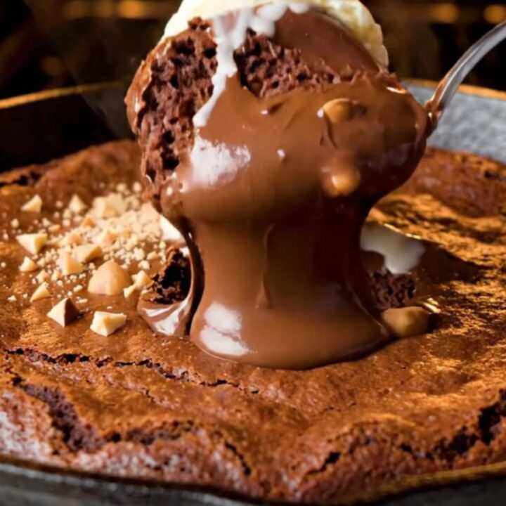 Warm skillet brownie with a crackly top and a scoop of vanilla ice cream, with molten Nutella flowing out