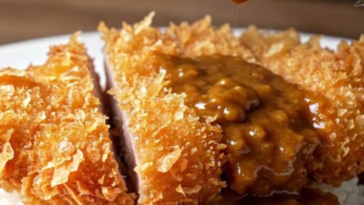 Sliced pork katsu curry over rice with pickled radish