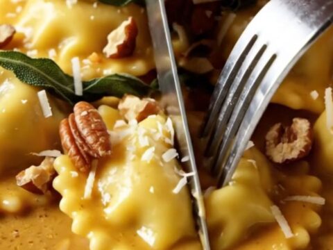 Creamy butternut squash ravioli in a brown butter sauce topped with crispy sage leaves and toasted pecans