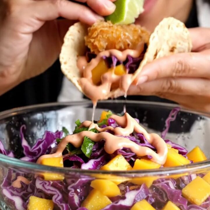 Crispy Baja fish taco with golden beer-battered fish, mango slaw, and chipotle crema on a charred corn tortilla