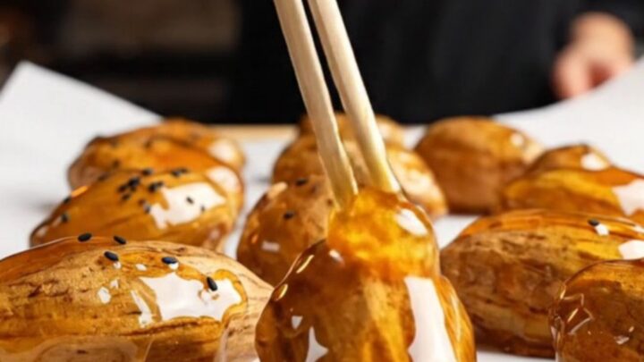 Korean candied sweet potatoes with glossy caramel shell and black sesame seeds on parchment