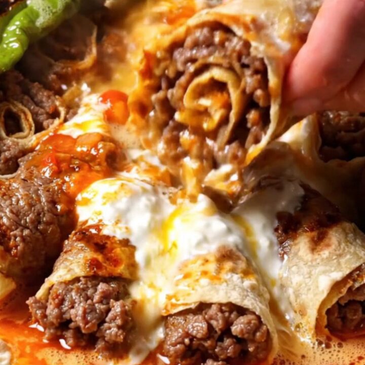 Sliced kebab rolls on a platter with yogurt, tomato sauce, and sizzling butter