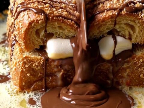 S'mores stuffed brioche French toast with melted chocolate and marshmallow, dusted with powdered sugar