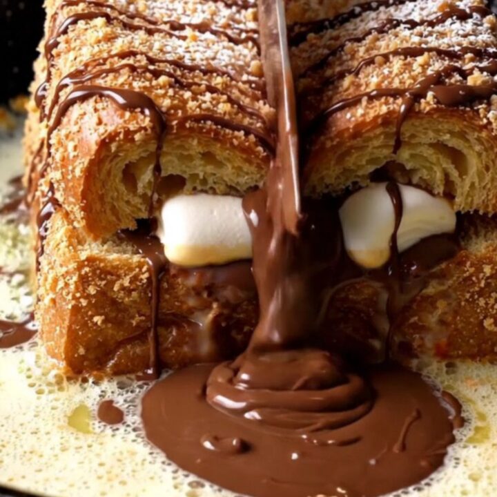 S'mores stuffed brioche French toast with melted chocolate and marshmallow, dusted with powdered sugar