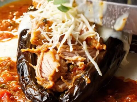 Fire-roasted stuffed poblano chile with melted Queso Oaxaca and charred salsa roja, garnished with crema and cilantro