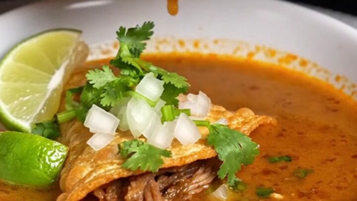 Crispy birria tacos with melted cheese being dipped into a bowl of rich consommé