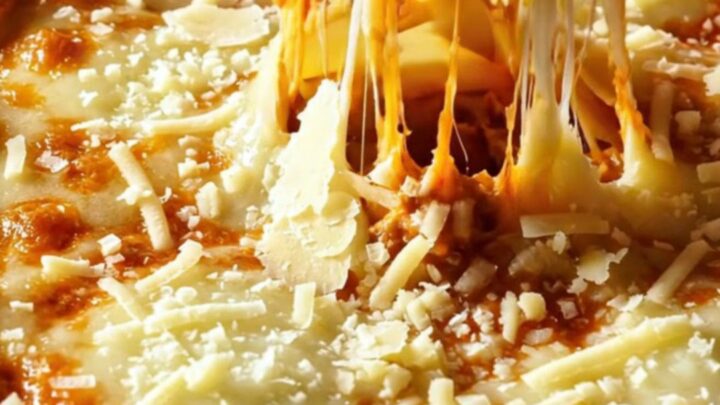 A slice of lasagna bolognese with layers of pasta, meat sauce, and melted cheese on a white plate.