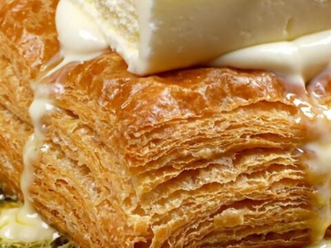 Golden blistered katmer pastry topped with a thick slice of Maraş ice cream and scattered pistachios