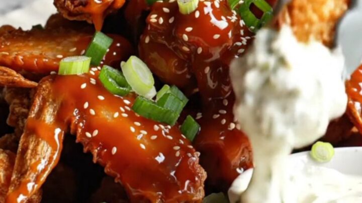 Golden crispy cauliflower wings glazed with sweet chili sauce, garnished with scallions and sesame seeds.