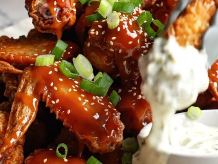 Golden crispy cauliflower wings glazed with sweet chili sauce, garnished with scallions and sesame seeds.