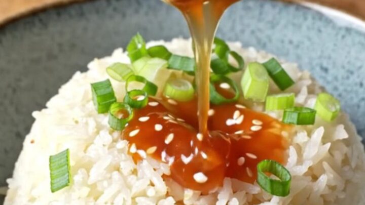 Glossy sweet chili meatballs on a bed of jasmine rice, topped with scallions and sesame seeds.