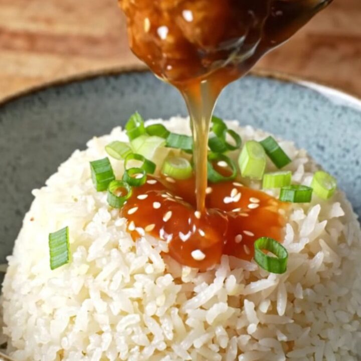 Glossy sweet chili meatballs on a bed of jasmine rice, topped with scallions and sesame seeds.