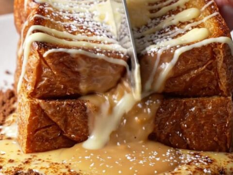Golden brioche French toast cut open with molten cookie butter flowing out