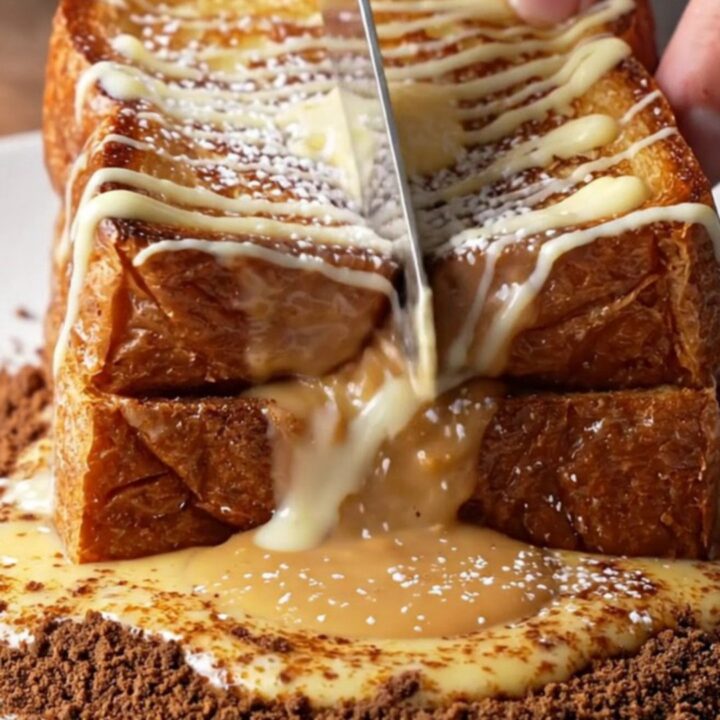 Golden brioche French toast cut open with molten cookie butter flowing out