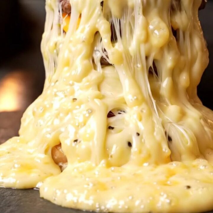 Quadruple Wagyu truffle smash burger with molten Raclette cheese cascading down the sides.