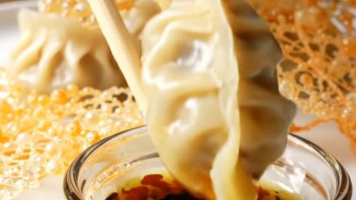 Golden lace skirt connecting crispy pork gyoza on a white platter