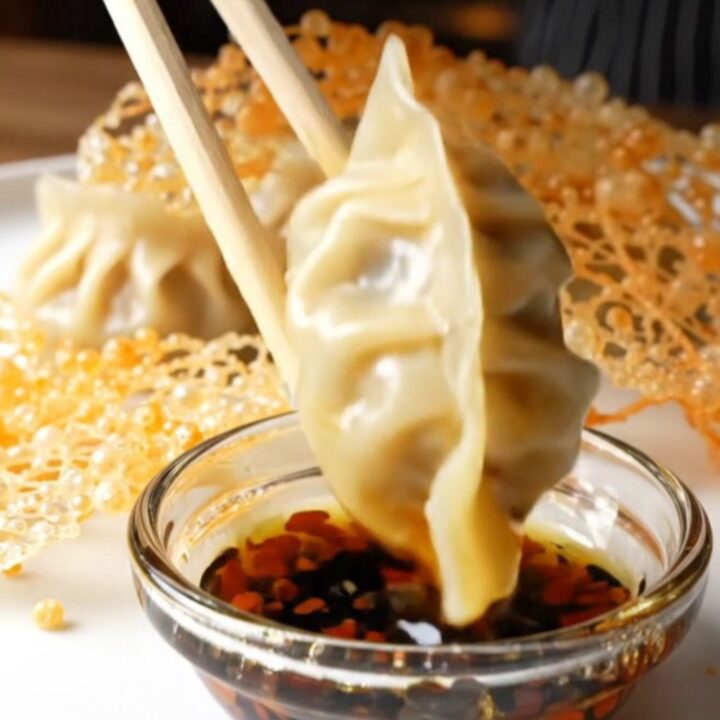 Golden lace skirt connecting crispy pork gyoza on a white platter