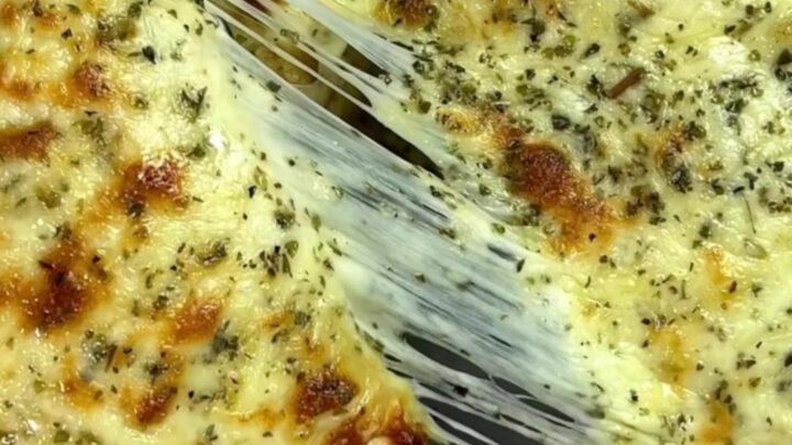 Golden brown tortilla pockets topped with melted mozzarella and fresh parsley, served on a wooden board.