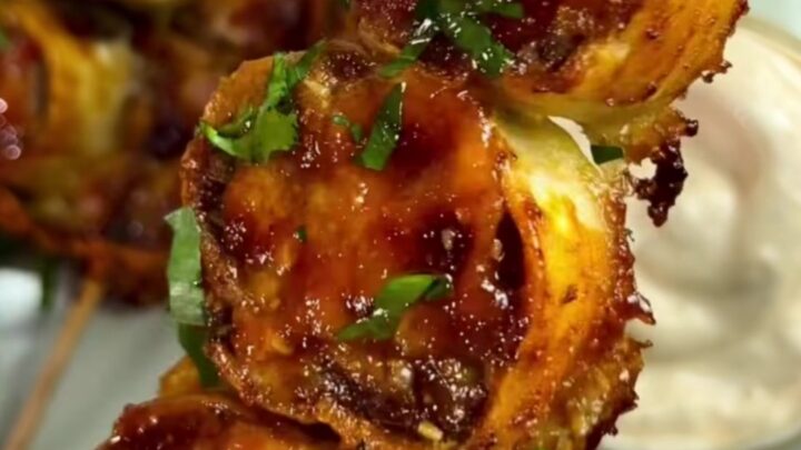 Skewer of glazed beef tortilla wheels with melted cheese and scallions
