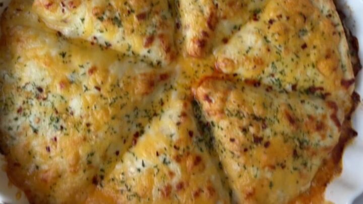 Golden baked beef pockets with melted cheese on top, garnished with parsley.