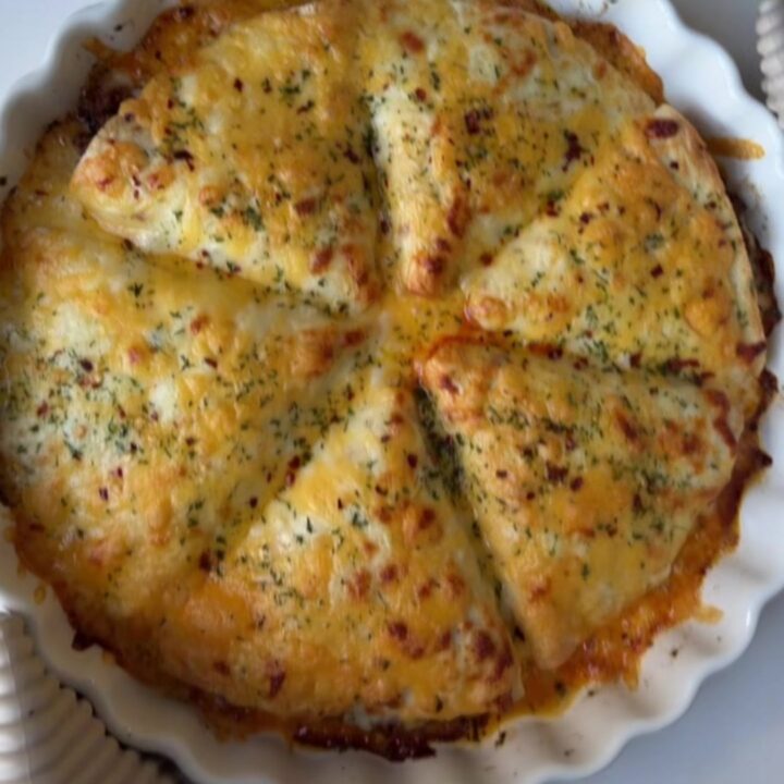 Golden baked beef pockets with melted cheese on top, garnished with parsley.