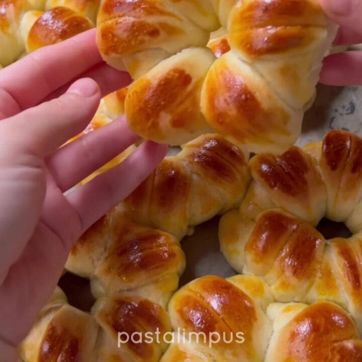 Golden flower-shaped brioche buns with sesame and nigella seeds on a baking sheet