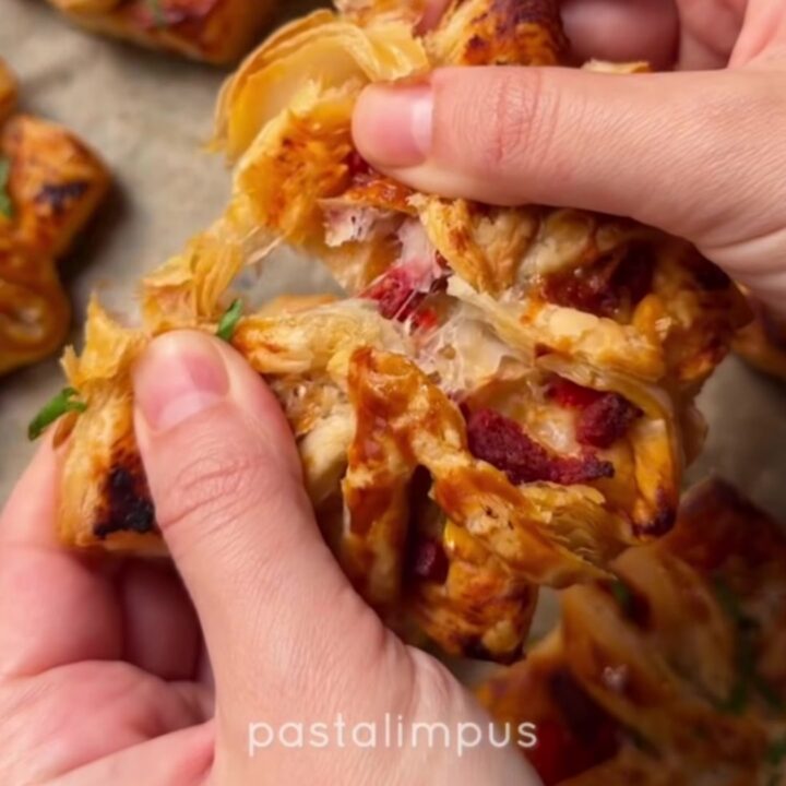 Golden puff pastry pizza flowers on a slate board with dried oregano