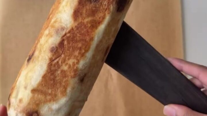 Crispy chicken lavash wrap cut in half, showing juicy chicken, melted cheese, and garlic sauce