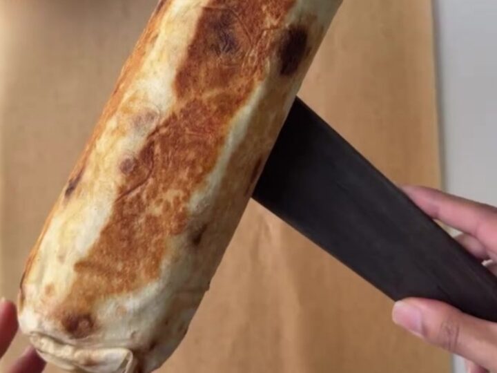 Crispy chicken lavash wrap cut in half, showing juicy chicken, melted cheese, and garlic sauce