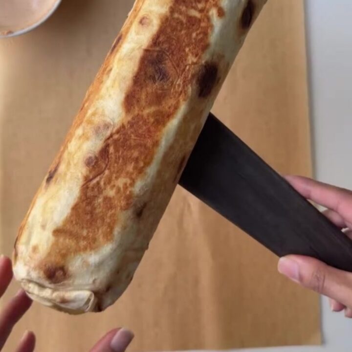 Crispy chicken lavash wrap cut in half, showing juicy chicken, melted cheese, and garlic sauce