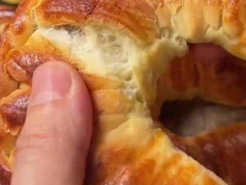 Golden braided Turkish buns with feta and herbs, showing soft, fluffy interior