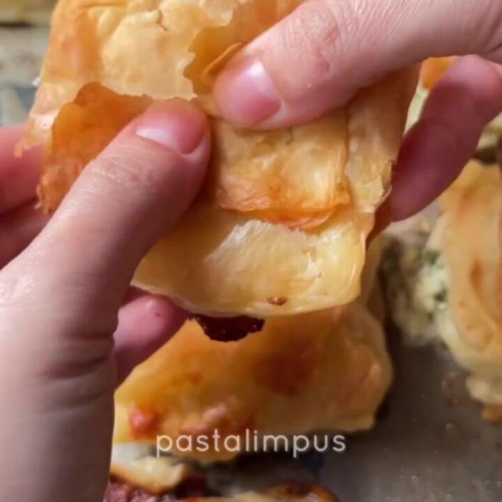 Golden spiral Turkish börek with crispy layers and beef filling on a round tray
