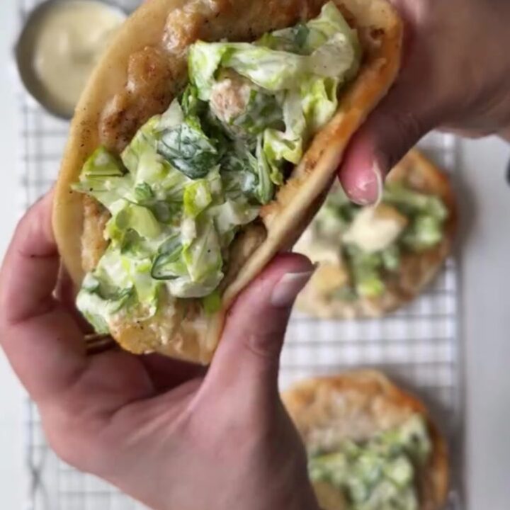 Crispy smashed chicken taco topped with Caesar salad and shaved parmesan