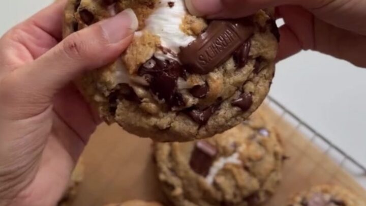 Warm s'mores cookie skillet with melted marshmallows and chocolate, sprinkled with sea salt.