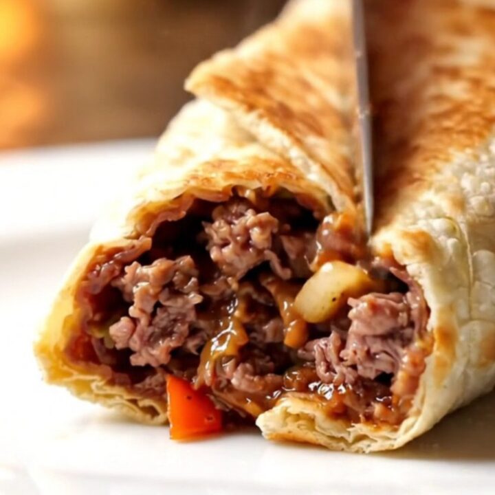 Crispy golden Antakya dürüm sliced in half showing juicy kebab, sumac onions, and parsley